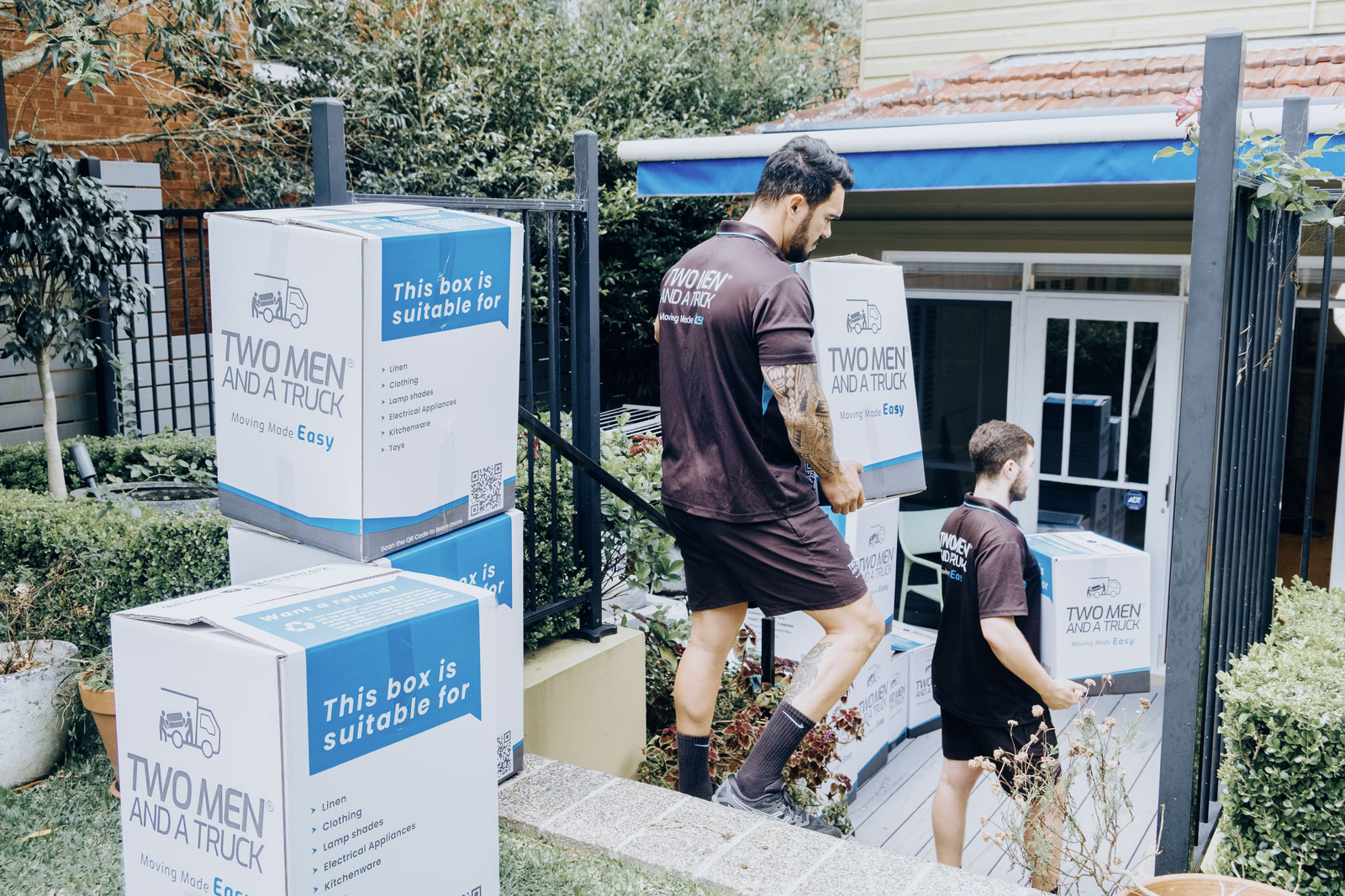 Moving house tips for packing – coloured labelled boxes stacked ready for removalists